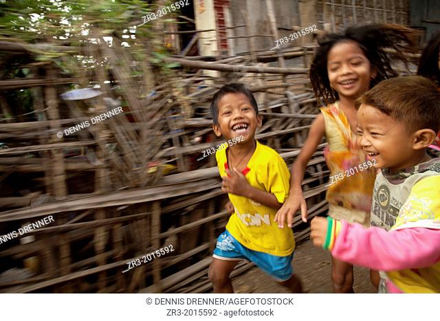 Young children run through a small village near Battambang, Cambodia