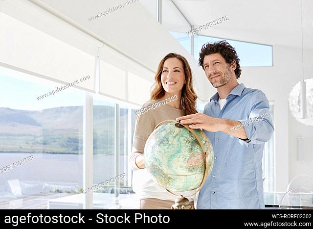 Couple with globe in a luxury villa