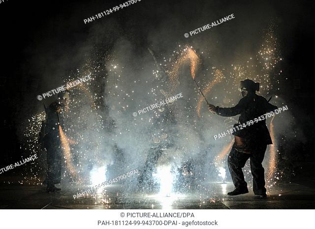 23 November 2018, Spain, Salvatierra: A man disguised as a devil dances in the middle of a ""firecracker inferno"" in the small town of Salvatierra