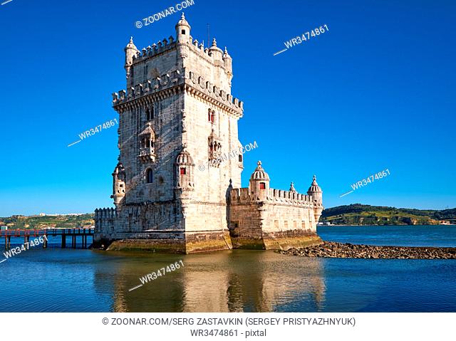Wide angle shot of Belem Tower (Tower of St Vincent) on river Tagus in Lisbon with reflection in water on blue sky background, Portugal