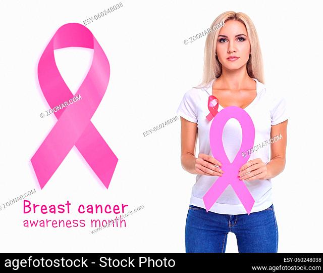 Beautiful blonde woman showing pink ribbon to support breast cancer, on the white background