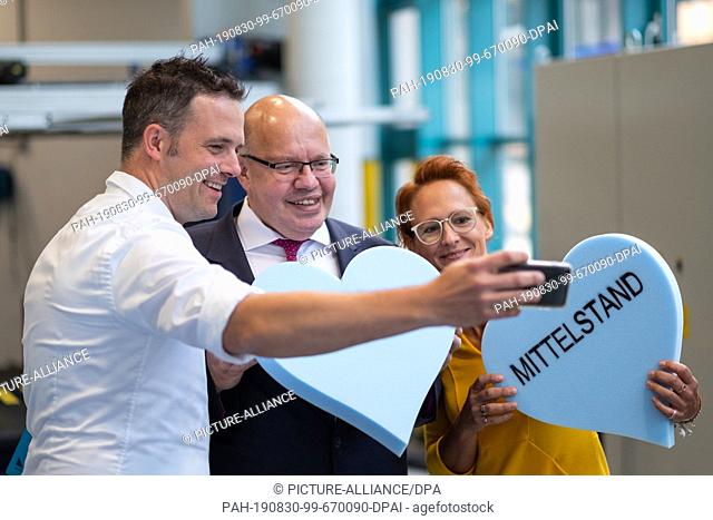 30 August 2019, North Rhine-Westphalia, Freudenberg: Peter Altmaier (M, CDU), Federal Minister of Economics, smiles for a selfie when visiting the machine...
