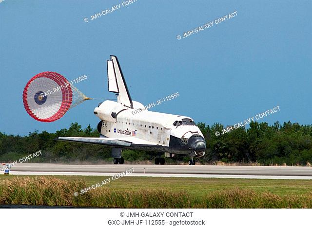 Space shuttle Discovery's drag chute is deployed as the spacecraft rolls toward wheels stop on Runway 15 at the Shuttle Landing Facility at NASA's Kennedy Space...