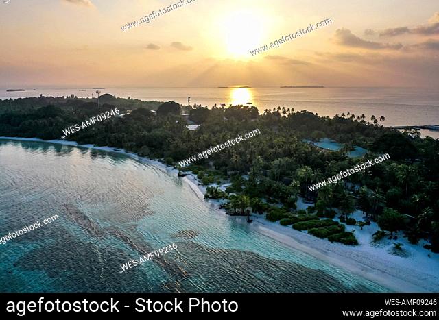 Maldives, Lhaviyani Atoll, Kuredu, Aerial view of sun rising over small resort island