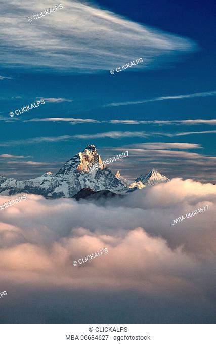 The massive Matterhorn emerging out of the clouds at sunrise. Next to it, another majestic peak, the Weisshorn - from one of the peak in the Mont Avic natural...