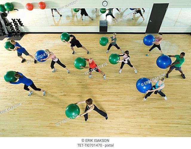 Fitness class holding balance balls