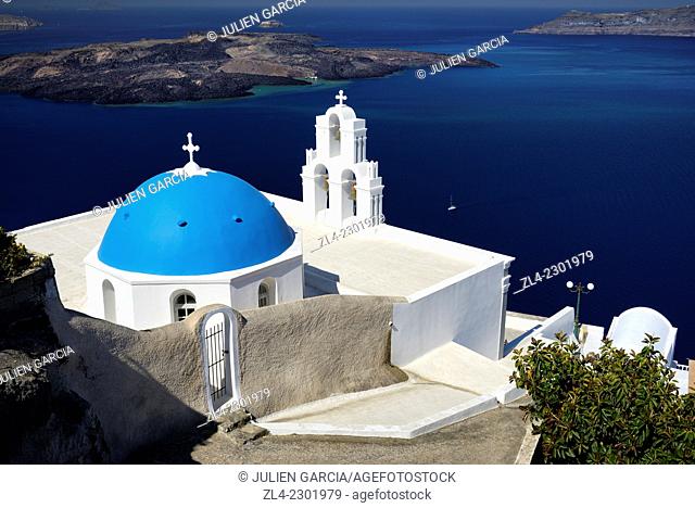 Greek orthodox church with blue dome in the village of Fira overlooking the caldera and the volcanic island of Nea Kameni
