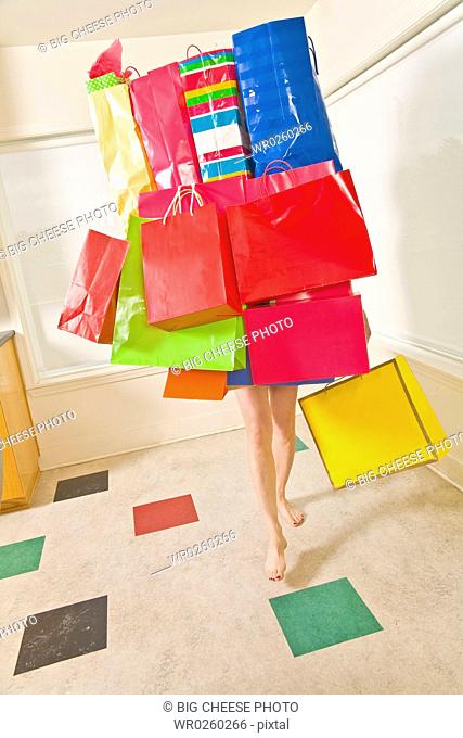 Woman balancing assorted shopping bags