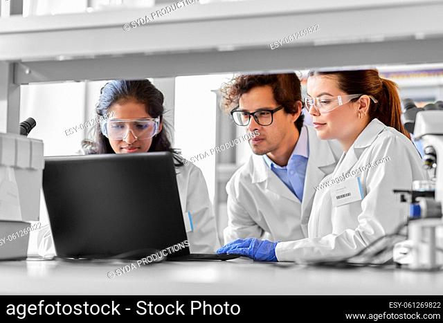 scientists with laptop working in laboratory