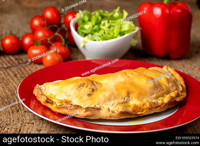 pizza calzone on a red plate