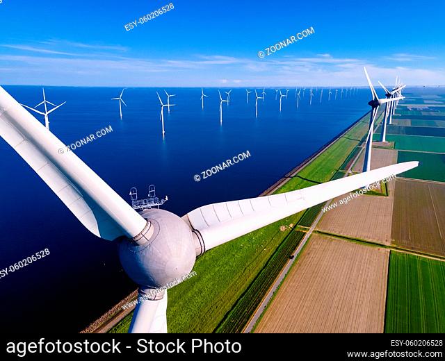 offshore windmill park with clouds and a blue sky, windmill park in the ocean aerial view with wind turbine Flevoland Netherlands Ijsselmeer