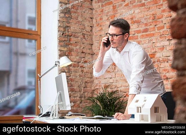 Businessman talking on smart phone at work place