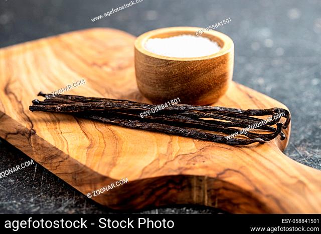 Vanilla pods. Sticks of vanilla and white sugar on cutting board