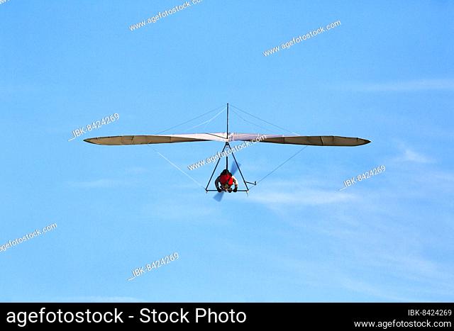 Motorised hang glider flying in slightly cloudy sky, text free space, Malmö, Sweden, Europe