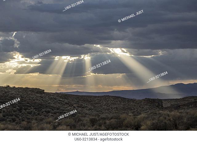 Stormy skies pass through the Southern Utah landscape and produce sunbeams at sunset