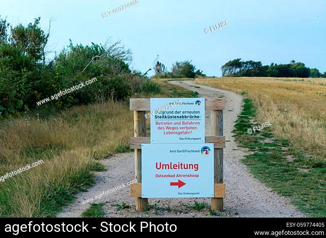 White warning sign with inscription in German - beware of cliffs on the Baltic Sea on the Darss