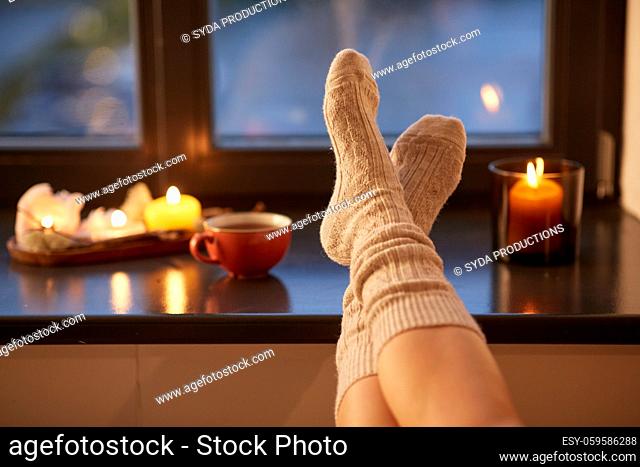 legs in socks on window sill at home in autumn