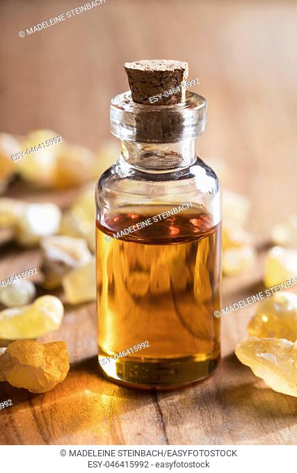 A transparent bottle of frankincense essential oil with frankincense resin