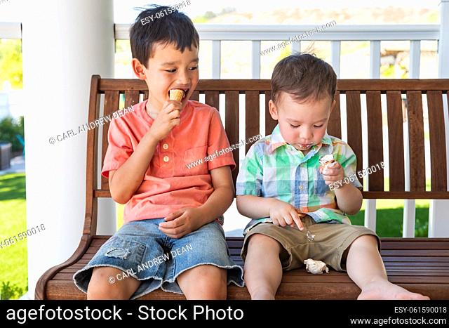 Young Mixed Race Chinese and Caucasian Brothers Enjoying Their Ice Cream Cones