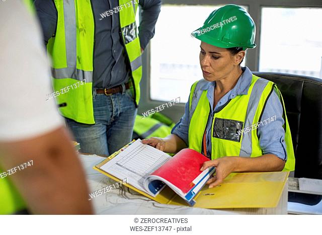 Female quarry worker checking files in office