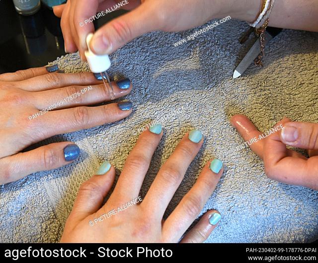 24 March 2023, Saxony, Leipzig: At the ""Grand Beauty"" salon in Robert Koch Park in Leipzig's west, a young woman has her fingernails painted by makeup artist...