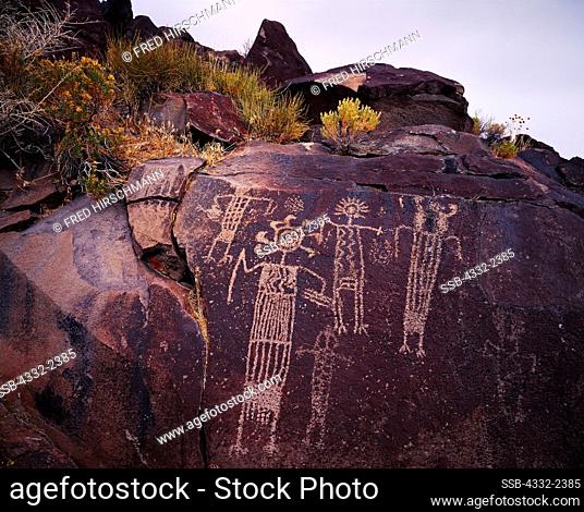 Coso Range Style petroglyphs of highly decorated anthropomorphs carved on a basalt wall, Renegade Canyon, Naval Air Weapons Station, China Lake, California