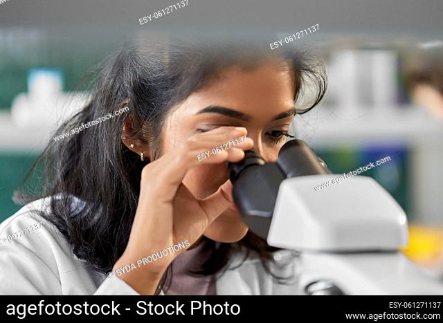 scientist with microscope working in laboratory