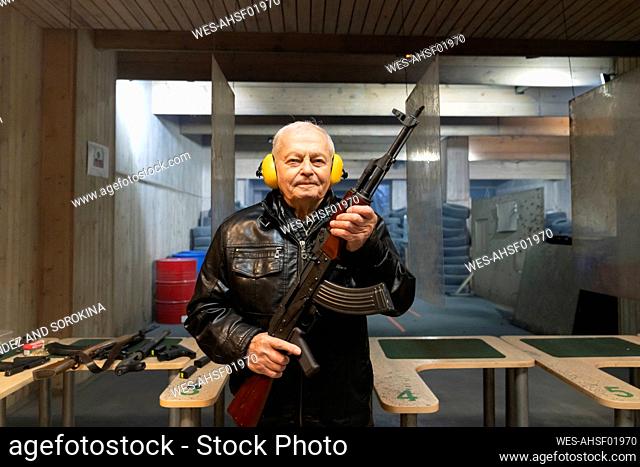 Portrait of senior man with a gun in shooting range