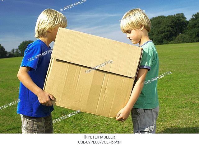two boys holding box