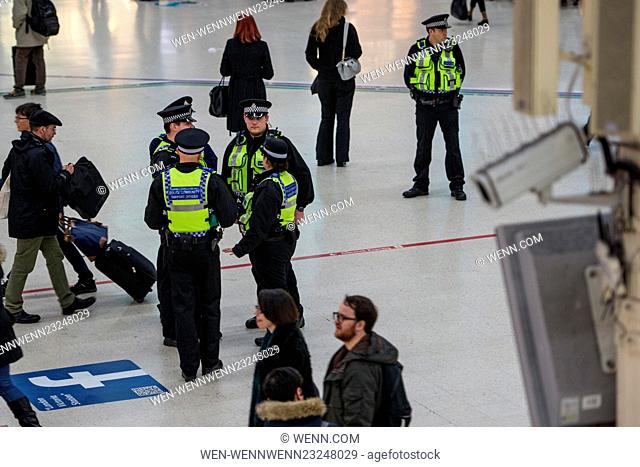 A CCTV camera watches from above as officers guard Victoria Station. The Metropolitan Police are posting more officers in Underground Stations following the...