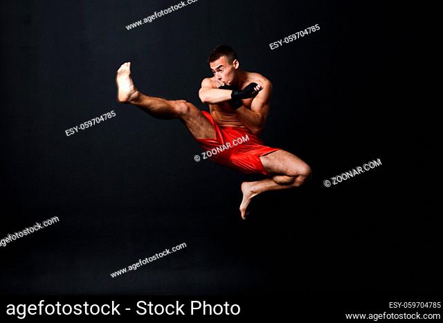 Sportsman muay thai man boxer stance at black background
