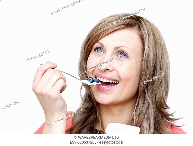 Cute woman eating a yogurt against a white background