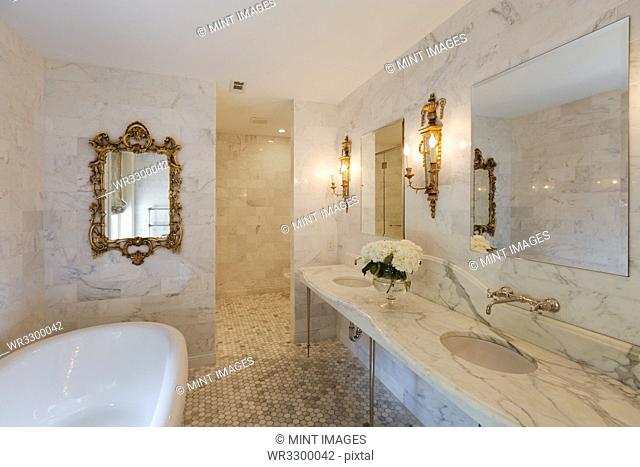 Bathtub and mirrors in ornate bathroom