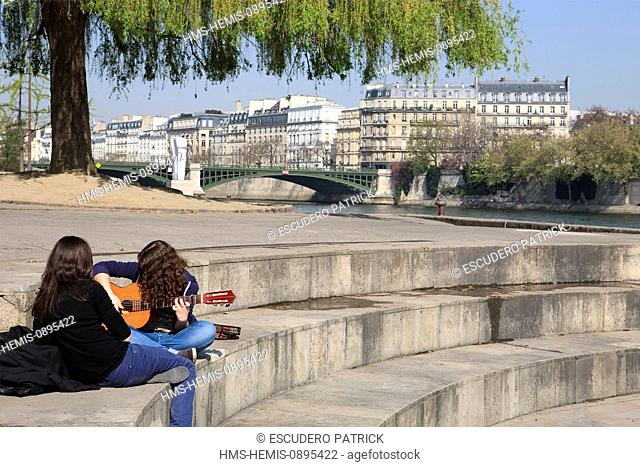 France, Paris, area listed as World Heritage by UNESCO, young woman playing guitar on Quai Saint Bernard in Tino Rossi garden