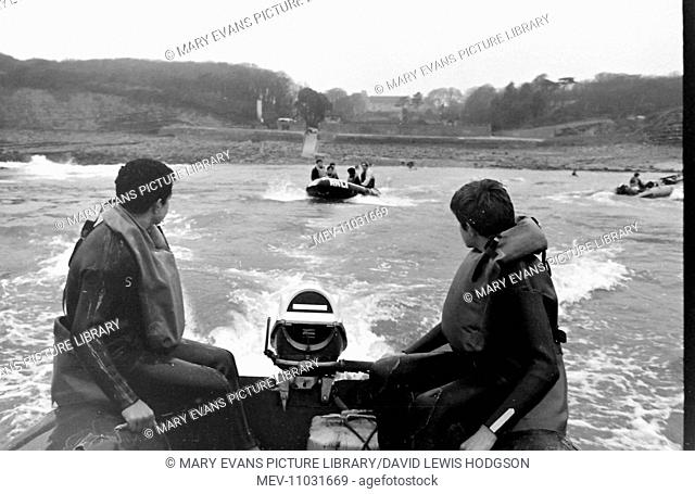 Schoolboys in motor-powered inflatable dinghies on the sea near Atlantic College (United World College of the Atlantic), St Donat's Castle, Llantwit Major