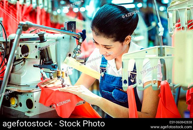 Asian seamstress in textile factory manufacturing apparel for the export market