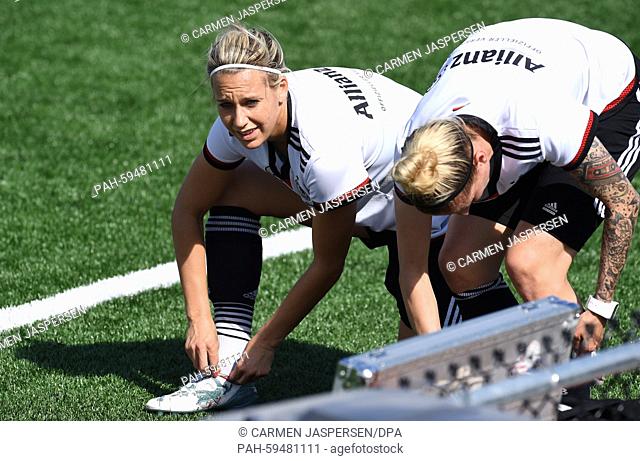 Germany-s Lena Goessling (l) and Anja Mittag change their shoes during a training session at the FIFA Women's World Cup 2015 at the Avenue Bois-de-Boulogne