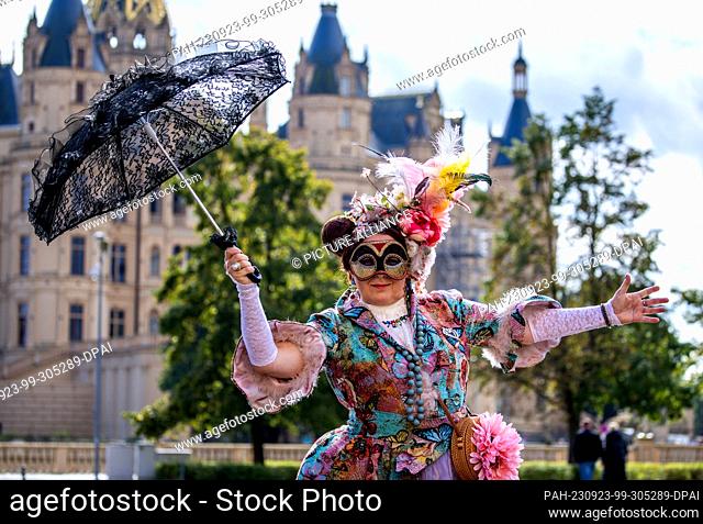 23 September 2023, Mecklenburg-Western Pomerania, Schwerin: With her costume, a member of the group ""Lustwandler"" from Hanover stands next to around 300...
