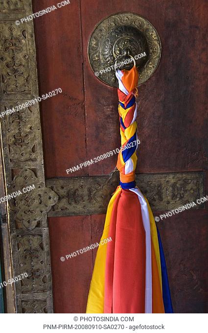Close-up of a prayer flag hanging with a door knocker in a monastery, Thiksey Monastery, Ladakh, Jammu and Kashmir, India