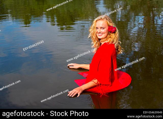 Portrait blonde dutch woman standing in natural water