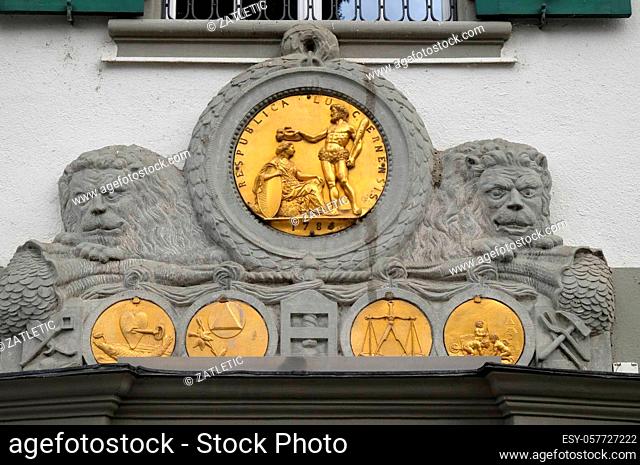Golden emblems on the exterior wall of a building at Muehlenplatz in Lucerne, Switzerland