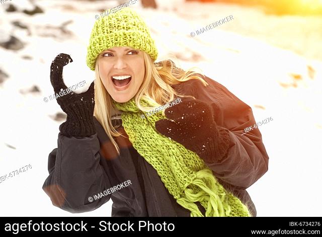 Attractive woman having fun in the snow on a winter day