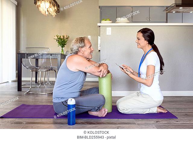 Physical therapist with digital tablet talking to man