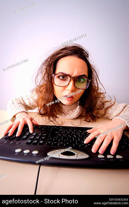 The funny nerd girl working on computer
