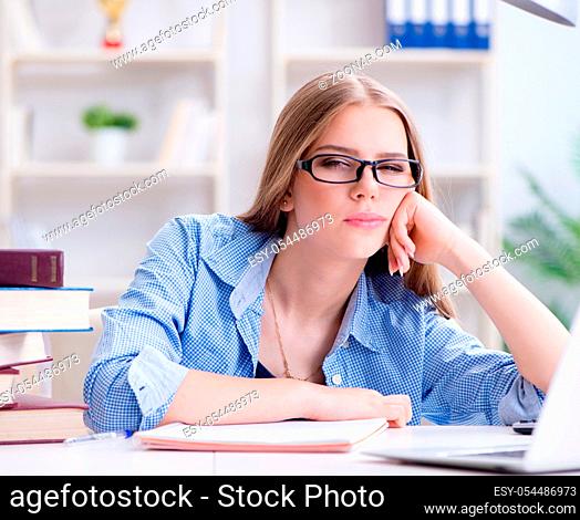 The young teenage female student preparing for exams at home