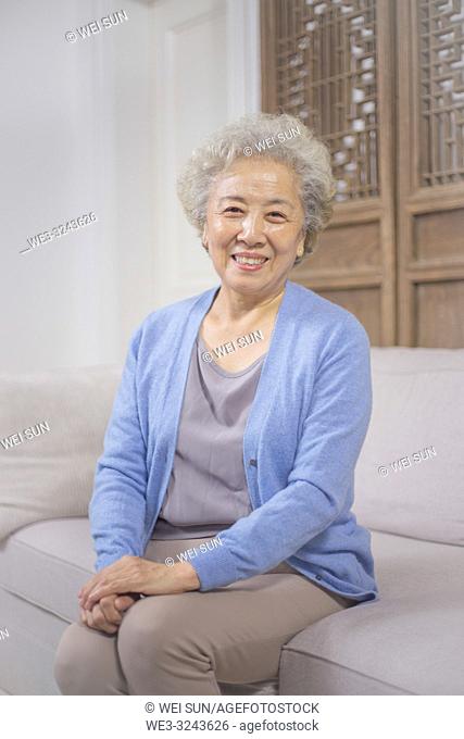Happy senior woman sitting on sofa