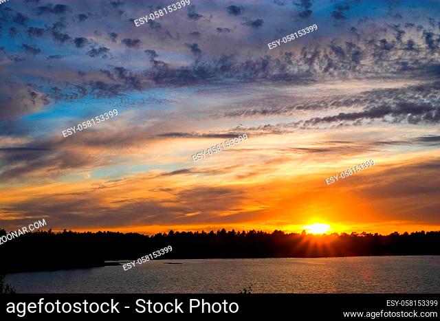 Dramatic and colorful sunset over a forest lake reflected in the water. Blakheide, Beerse, Belgium. High quality photo