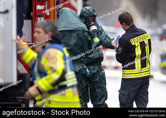 09 January 2023, North Rhine-Westphalia, Castrop-Rauxel: Special firefighters in protective suits come back from their mission