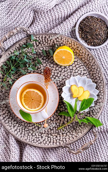 Healthy detox ginger and sage tea with lemon on tray