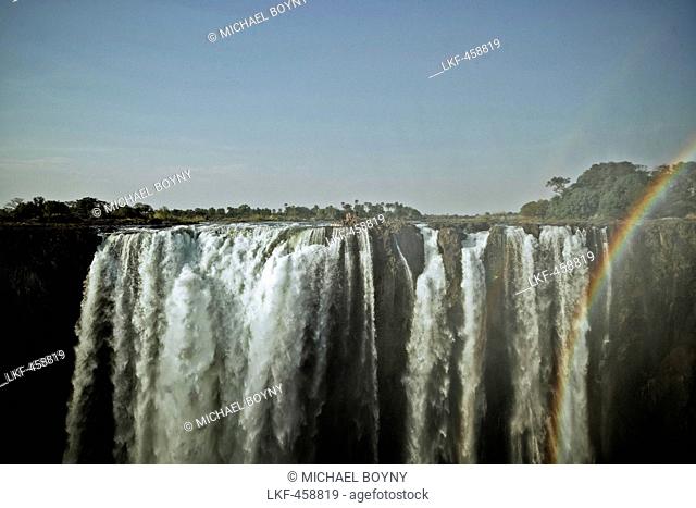 A group of people standing at the edge of Victoria Falls, Sambia, Africa